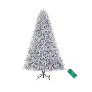 A snow-flocked artificial Christmas tree with dense branches, featuring multicolored lights and a sturdy metal stand.