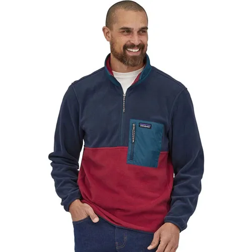 A man wearing a tri-color fleece pullover with a zipper collar and a chest pocket.