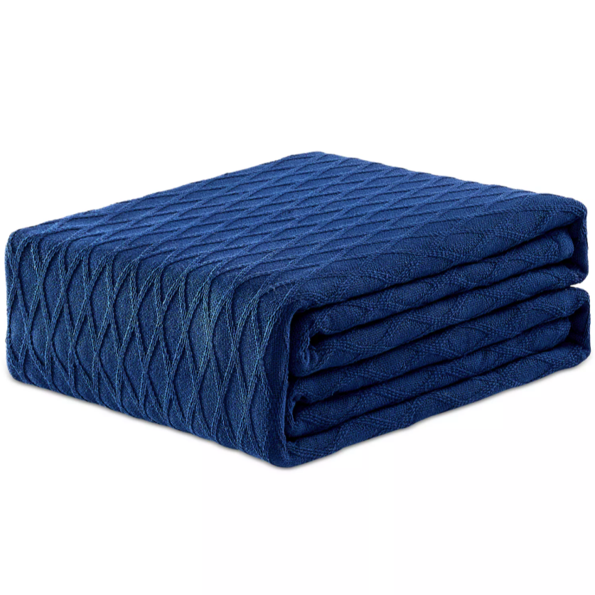 A folded blue blanket with a textured diamond pattern.