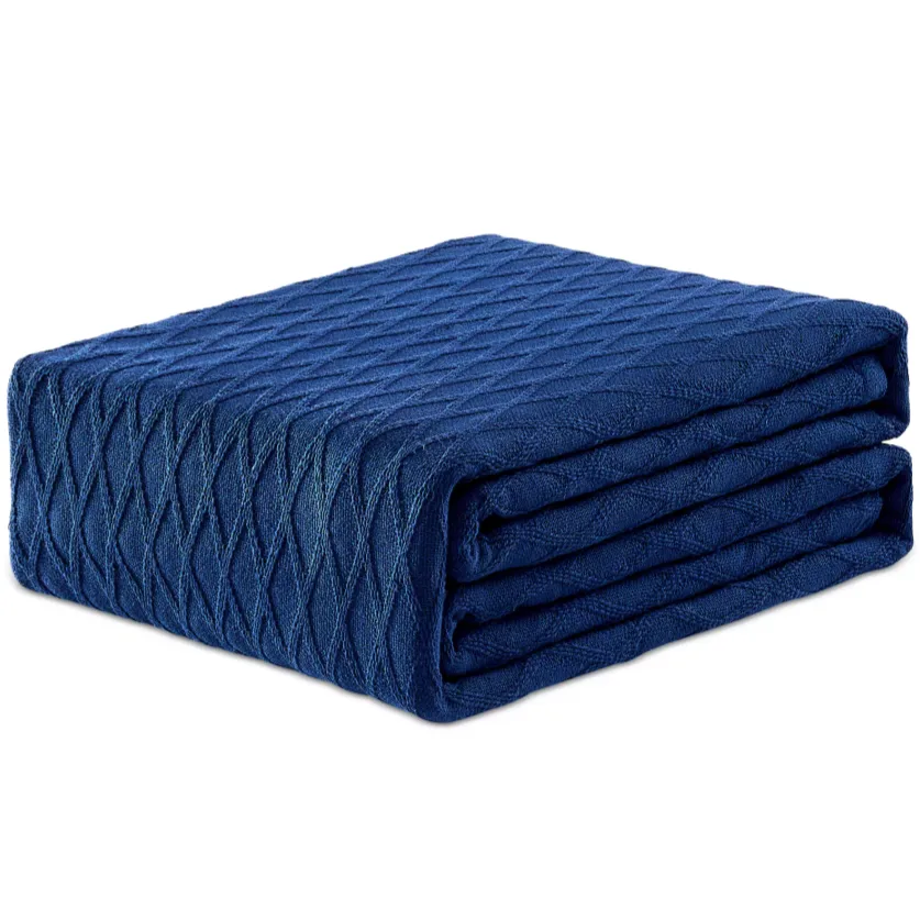A folded blue blanket with a textured diamond pattern.