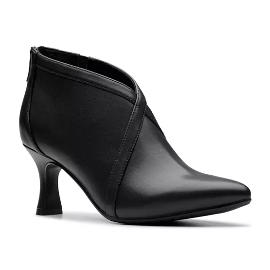 Clarks Kataleyna Comfort Booties are black ankle boots with a sleek design, featuring a pointed toe and mid-height heel. They have a decorative crisscross detail on the front and a back zipper for easy wear.