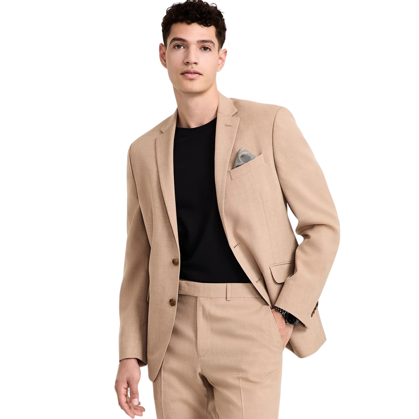 A man is wearing a tan suit with a black shirt, featuring a pocket square in the blazer's chest pocket. The suit is paired with matching trousers.