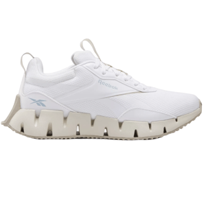 Reebok Zig Dynamica STR Shoes feature a white mesh and synthetic build with a distinctive zigzag midsole design for cushioning and style. They include pull tabs on the tongue and heel, and subtle Reebok branding in light blue.