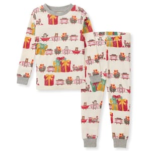 This is a children's organic cotton pajama set featuring a festive print with gifts, drums, and toy trains on an off-white background, finished with grey cuffs.