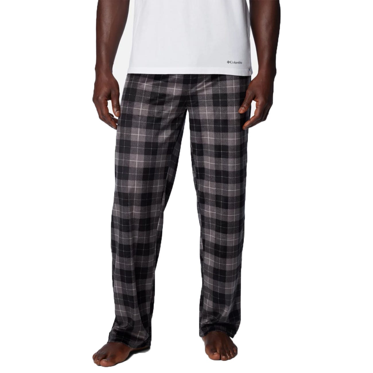 Man wearing black and gray plaid pajama pants with a white \“Columbia\“ branded T-shirt.