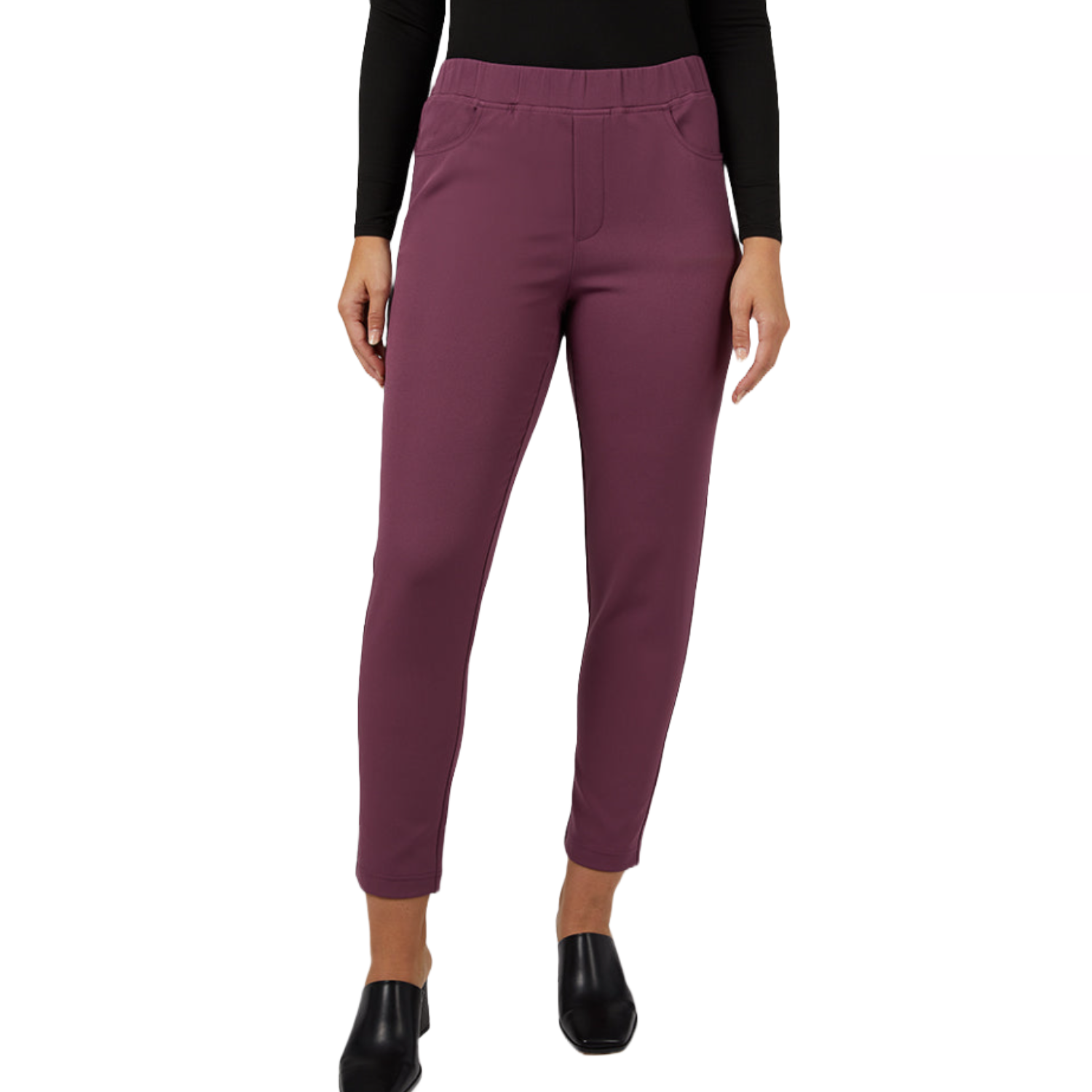 A person wearing high-waisted, ankle-length maroon pants, paired with a black long-sleeve top and black slip-on shoes.
