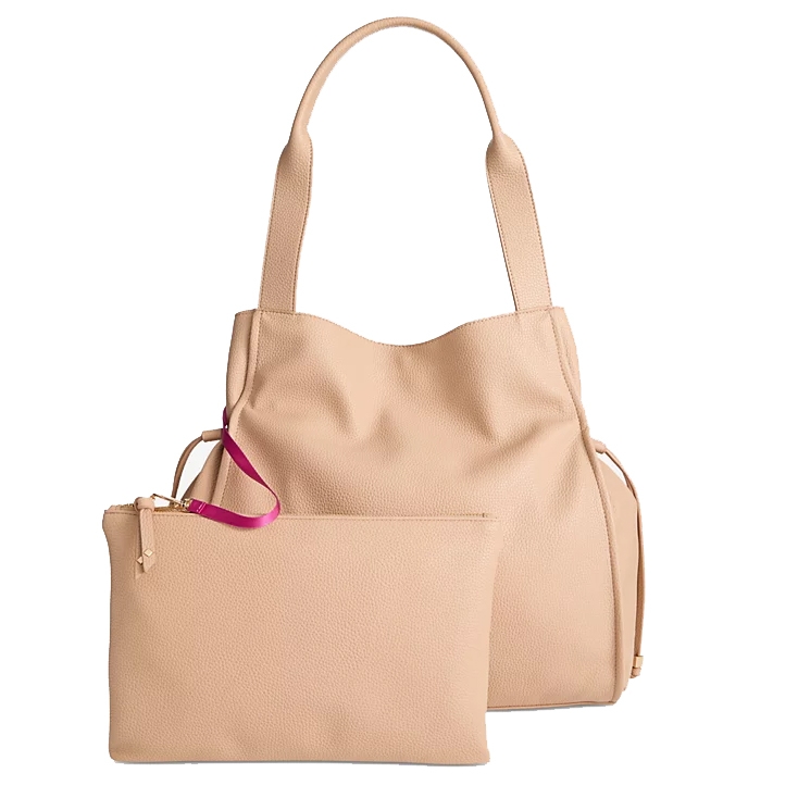 A beige tote bag with large handles, featuring a removable zippered pouch. The pouch has a contrasting fuchsia strap attached to the zipper. Both pieces have a textured finish.