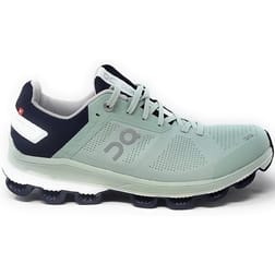 The On Women's Cloudsurfer 6 Shoes are mint green and navy athletic sneakers featuring a mesh upper for breathability and distinct CloudTec cushioning for a comfortable ride.