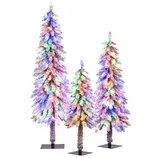Set of three artificial Christmas trees with multicolored lights, featuring a frosted, snowy appearance. The trees are of varying heights and have square bases.