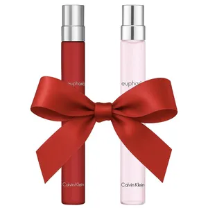 Two Calvin Klein Euphoria perfume bottles, one red and one pink, are adorned with a large red ribbon.