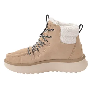 A beige high-top boot with a thick sole features a lace-up design and a contrasting white sherpa lining for added warmth.