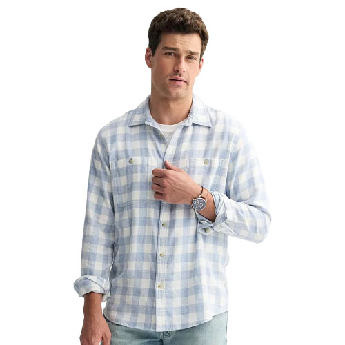 A man wearing a light blue and white checkered long-sleeve shirt, paired with light blue jeans.