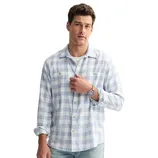 A man wearing a light blue and white checkered long-sleeve shirt, paired with light blue jeans.
