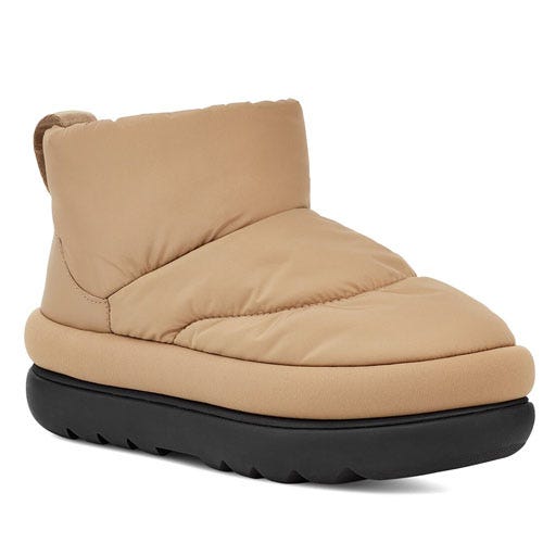 Tan, puffy ankle boots with cushioned upper, featuring a black chunky sole and designed for warmth and comfort.