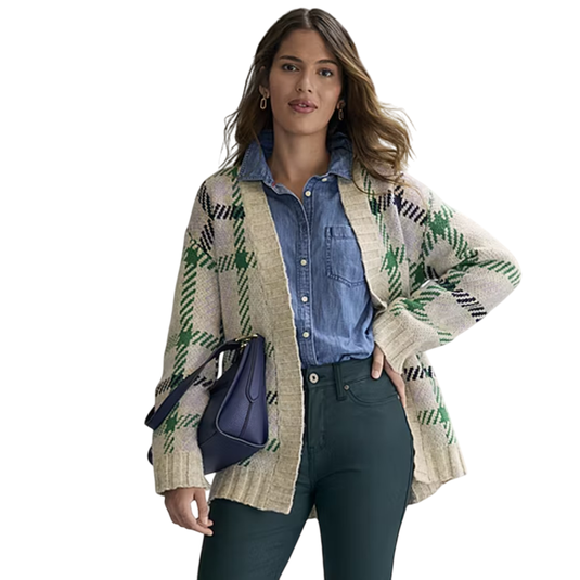 A woman models a beige and green plaid cardigan over a denim shirt, paired with dark green pants, holding a dark blue bag.