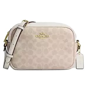 A Coach crossbody bag with a light beige monogram pattern, featuring a gold logo and a matching adjustable strap.