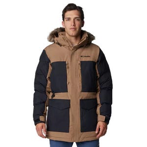 The Columbia Maximum Warmth Parka features a brown and black color scheme with a fur-lined hood. It has multiple large front pockets and is designed for cold weather insulation.