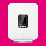 A white device with a small screen displaying connection status, featuring a magenta signal icon and navigation buttons, with a logo resembling a \“T\“ below the screen.