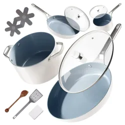A white cookware set with blue non-stick interiors includes pots, pans with glass lids, a wooden spoon, a spatula, and two protective pads.