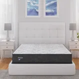 Sleepys mattress on a white upholstered bed frame with a quilted headboard, flanked by two white nightstands with lamps, set against a backdrop of two abstract blue wall art pieces.