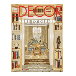A magazine cover for \“Elle Decor\“ features an elegant dining room with a long table and patterned chairs, surrounded by built-in bookshelves filled with books and decorative items.