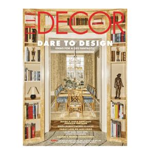 A magazine cover for \“Elle Decor\“ features an elegant dining room with a long table and patterned chairs, surrounded by built-in bookshelves filled with books and decorative items.