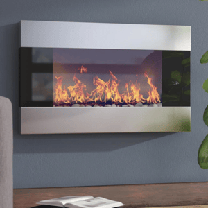 A sleek wall-mounted electric fireplace with a modern stainless steel finish featuring realistic flames and decorative pebbles. It's elegantly integrated into a living room setting with adjacent furniture and plants.