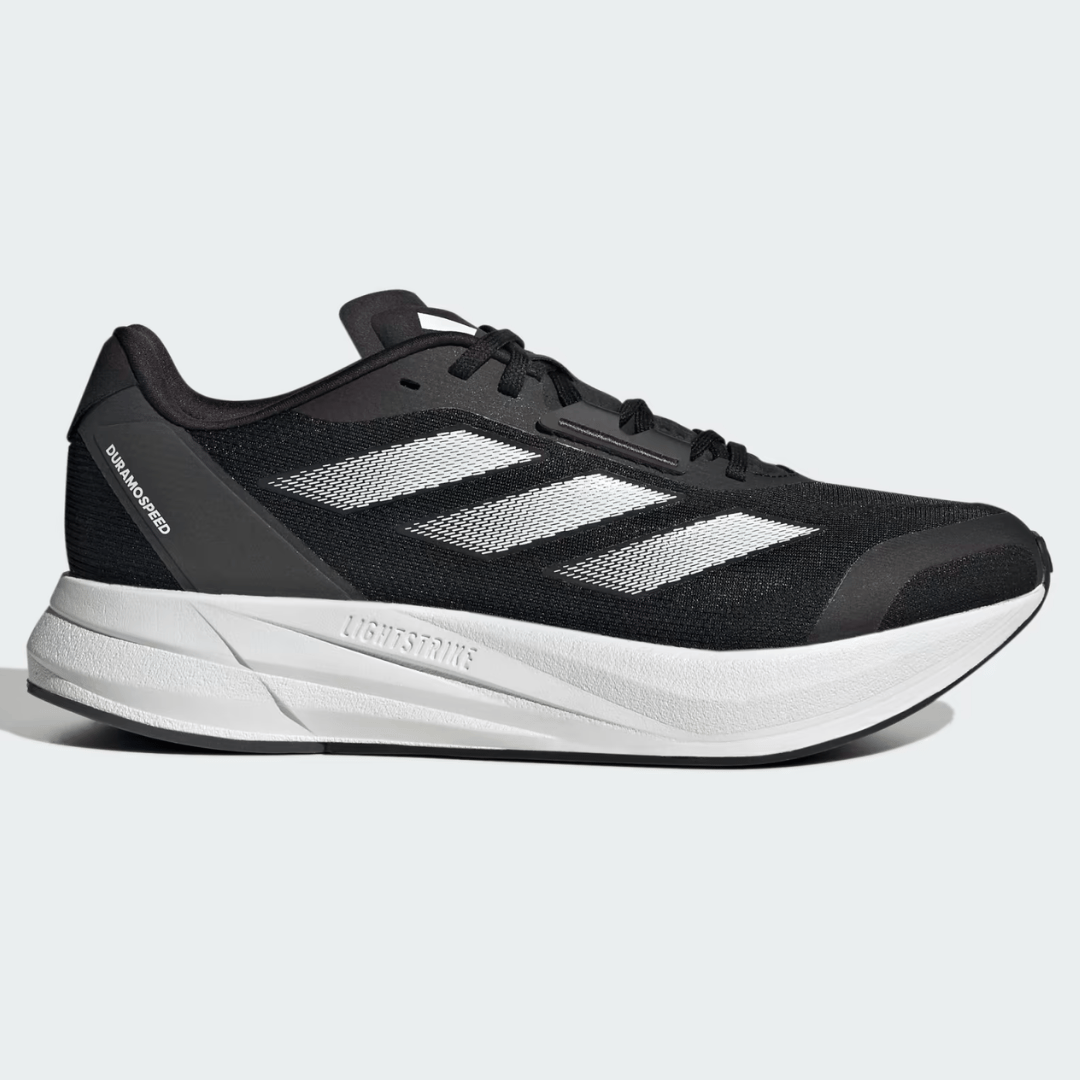 A black and white athletic shoe with a label reading \“lightstrike\“ on the white midsole and three stripes on the side.