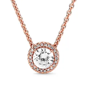 A rose gold necklace featuring a central round-cut gemstone surrounded by a halo of smaller stones, all set in a chain.