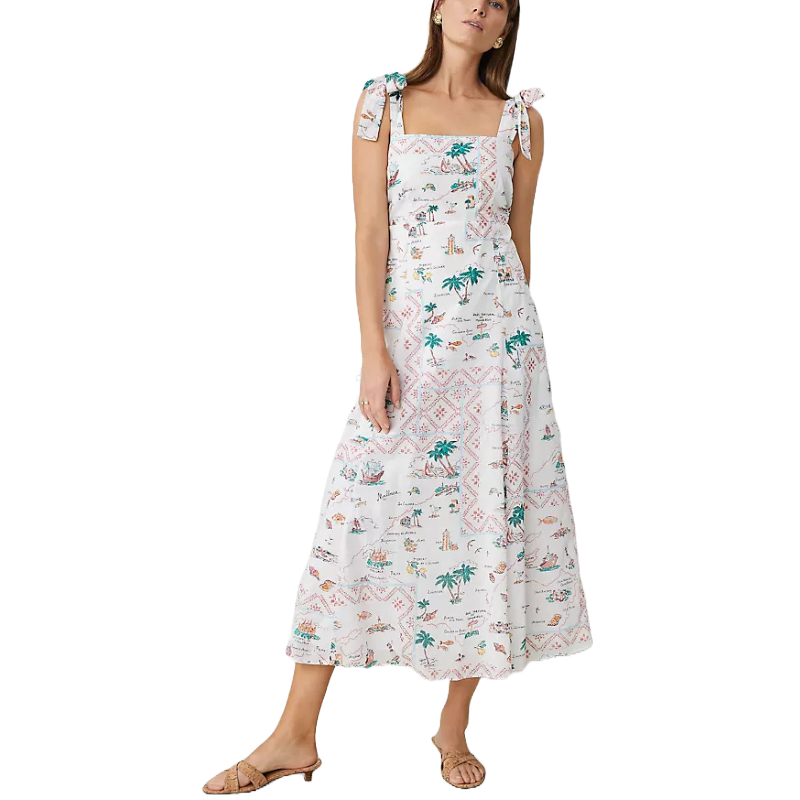 White midi dress with a map print featuring palm trees, boats, and landmarks, accented by shoulder tie straps. Paired with flat sandals.