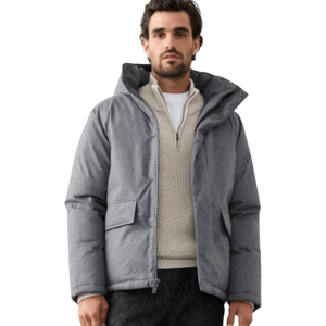 A man wearing a gray puffer jacket, cream textured sweater, black pants, and brown hiking boots.