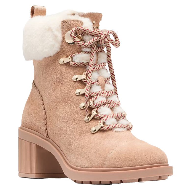 A tan ankle boot with fur trim and a chunky heel, featuring red and white striped laces and metal eyelets.