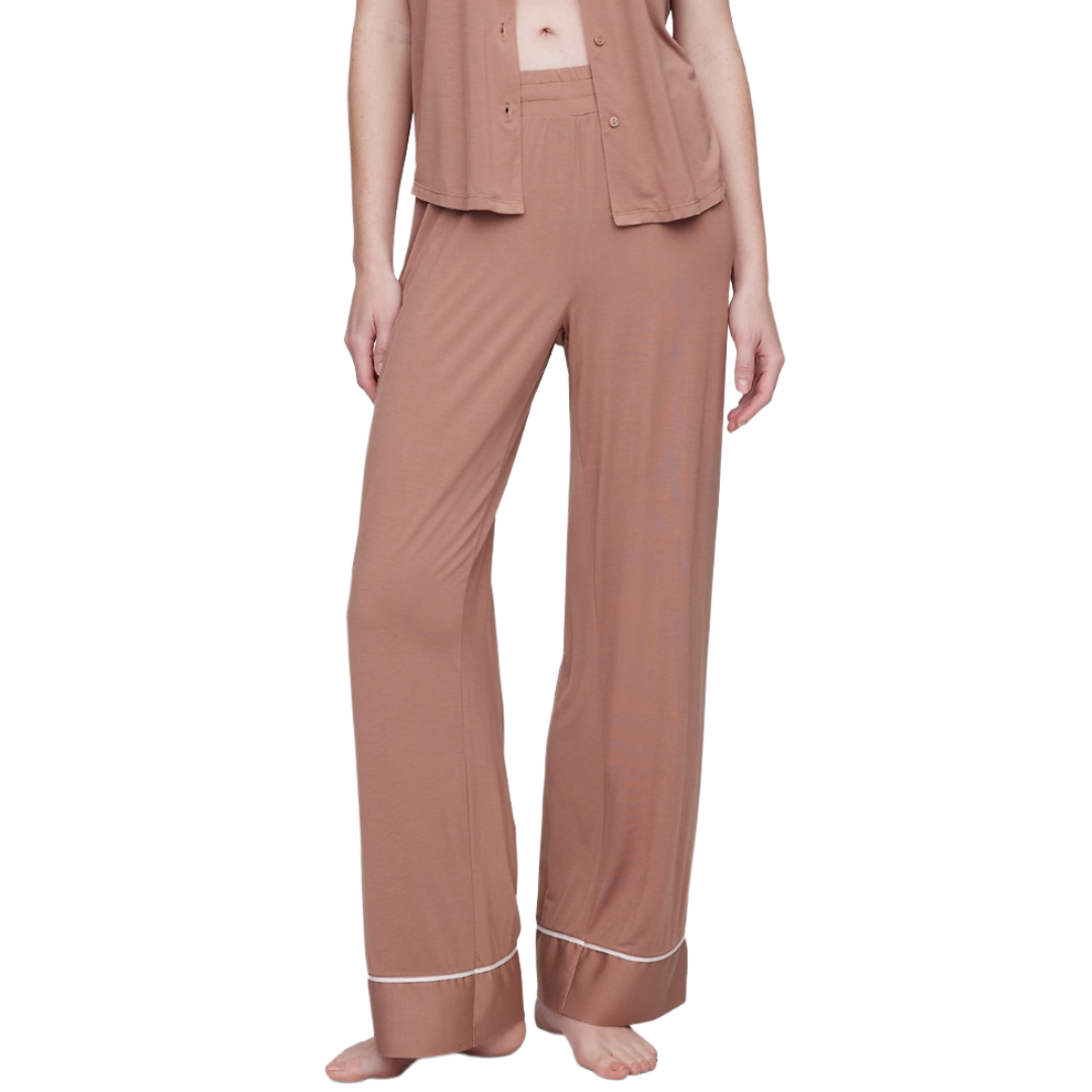 A pair of brown, wide-leg pajama pants with white piping at the cuffs. They are part of a matching pajama set with a button-up top.