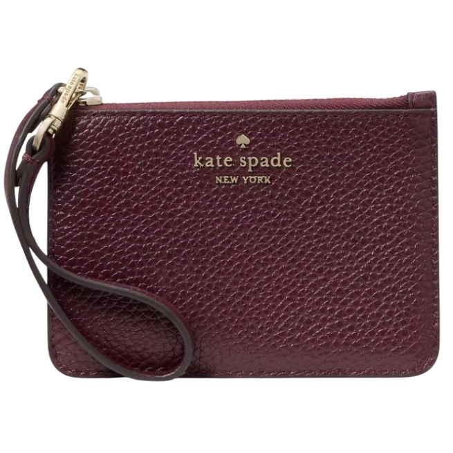 A small, textured leather wristlet in dark burgundy with \“kate spade NEW YORK\“ embossed in gold lettering. It features a wrist strap attached to a gold zipper pull.
