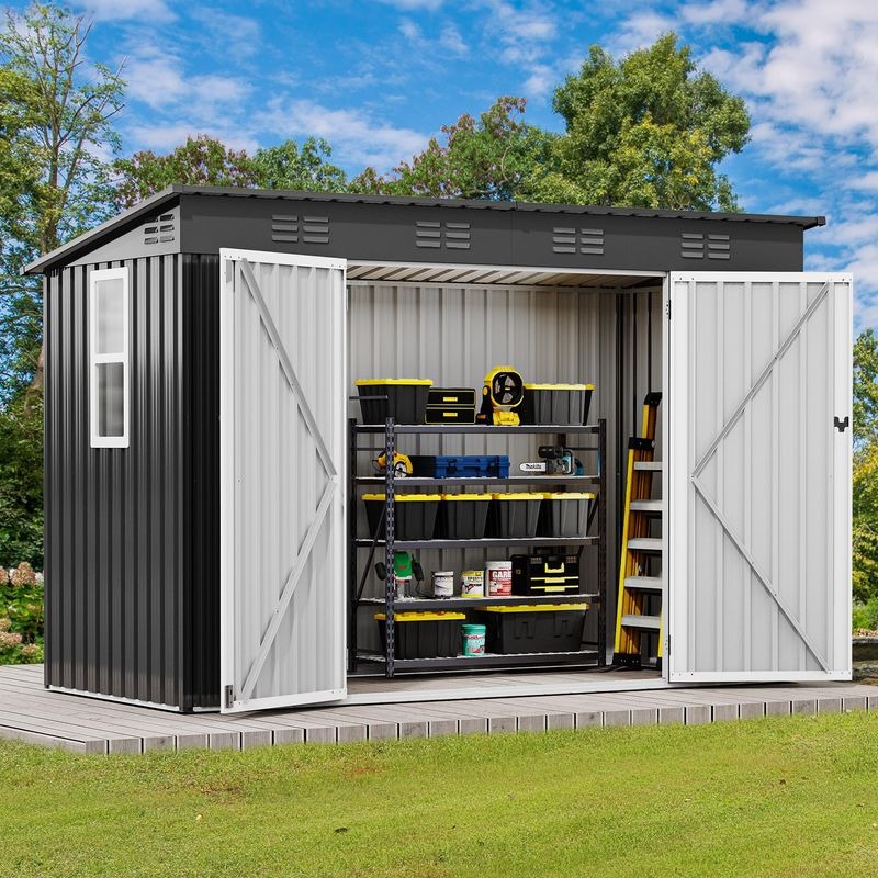 A metal storage shed with open double doors displays shelves stacked with toolboxes, paint cans, and a ladder, set on a wooden platform in a grassy area surrounded by trees.