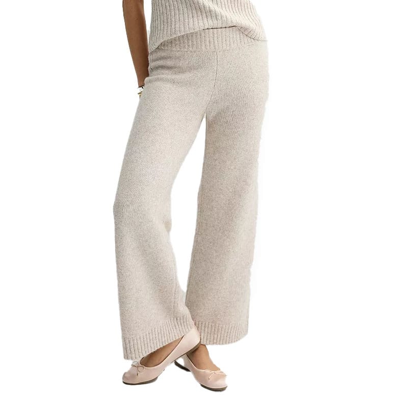 Cream-colored, wide-leg sweater pants made of a soft knit fabric with a ribbed waistband and hem, paired with ballet flats.