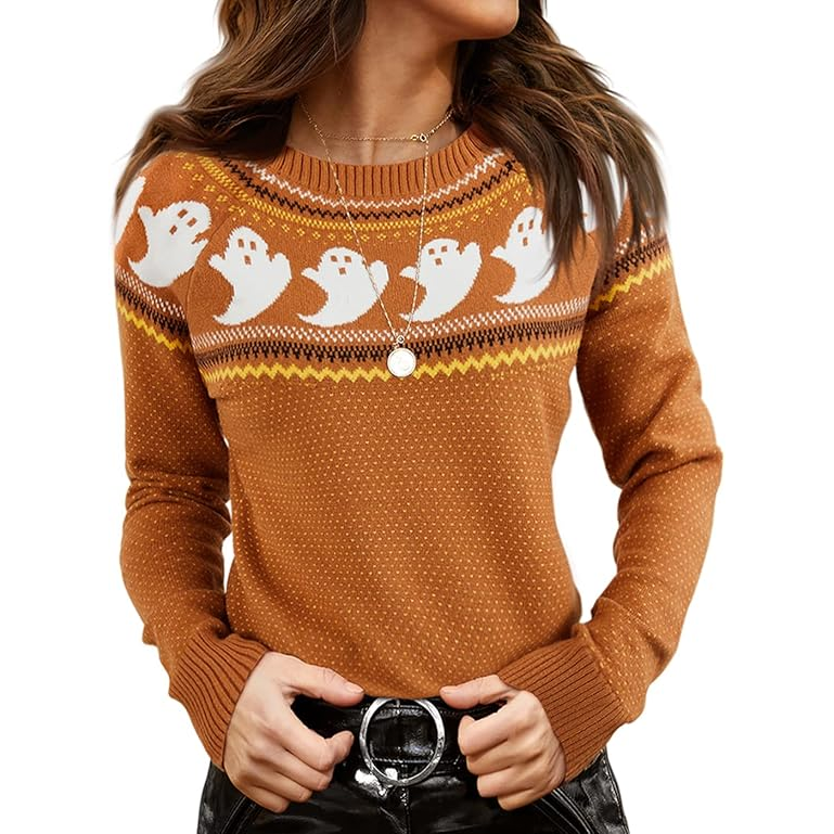 A rust-orange sweater with a cute ghost pattern and geometric designs in white and yellow across the chest and neckline. The wearer has styled it with circular pendant necklaces and a black belt.