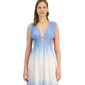 A woman is wearing a sleeveless ombre maxi dress with a deep V-neck. The dress transitions from light blue at the top to white at the bottom. A pink bikini top is visible underneath.