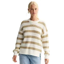 A woman is wearing a white and beige striped sweater with a ribbed texture and loose fit, paired with light blue jeans.
