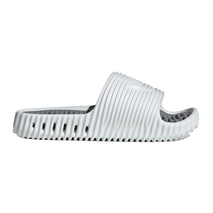 Adidas Men's Adilette 25 Slides feature a slip-on design with a textured white finish, ribbed pattern, and cushioned sole for comfort. They have open-toe styling with perforated details for breathability.