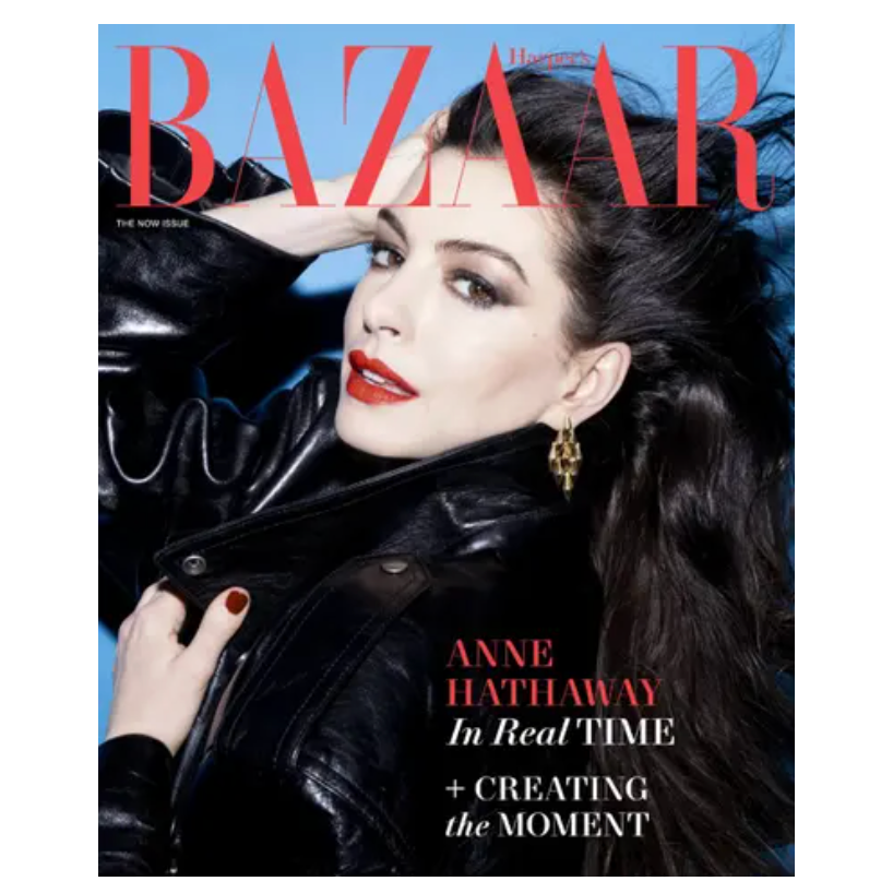 Harper's Bazaar cover featuring a person in a black leather jacket with red lipstick and gold earrings. Text highlights \“Anne Hathaway In Real Time\“ and \“Creating the Moment\“ against a blue background.