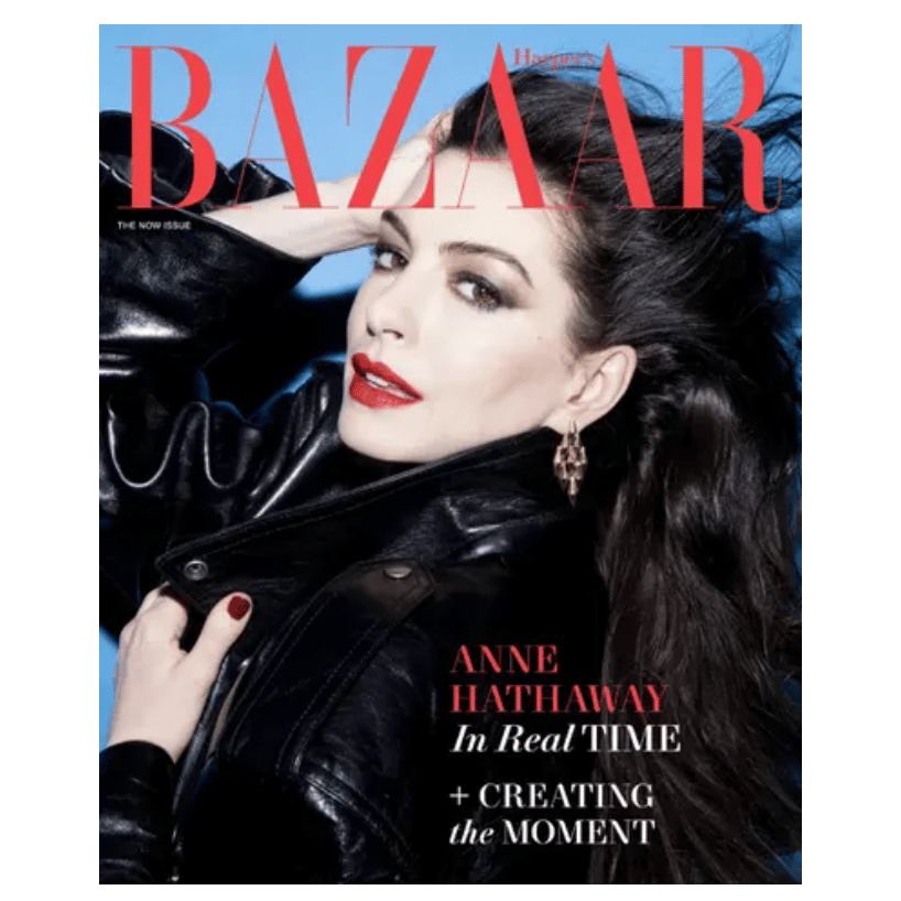 Harper's Bazaar cover featuring a person in a black leather jacket with red lipstick and gold earrings. Text highlights \“Anne Hathaway In Real Time\“ and \“Creating the Moment\“ against a blue background.