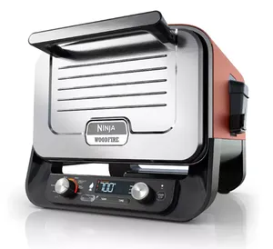 Ninja Woodfire electric grill with a digital display and control knobs, featuring a compact design suitable for indoor use.