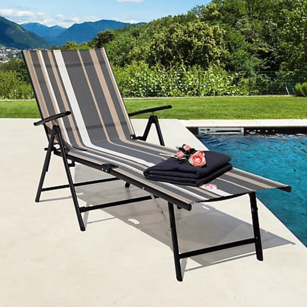 Steel chaise lounge chair with a black metal frame and a multi-colored striped fabric seat, positioned poolside beside blue water. It includes armrests and a folded black towel with pink roses on top.