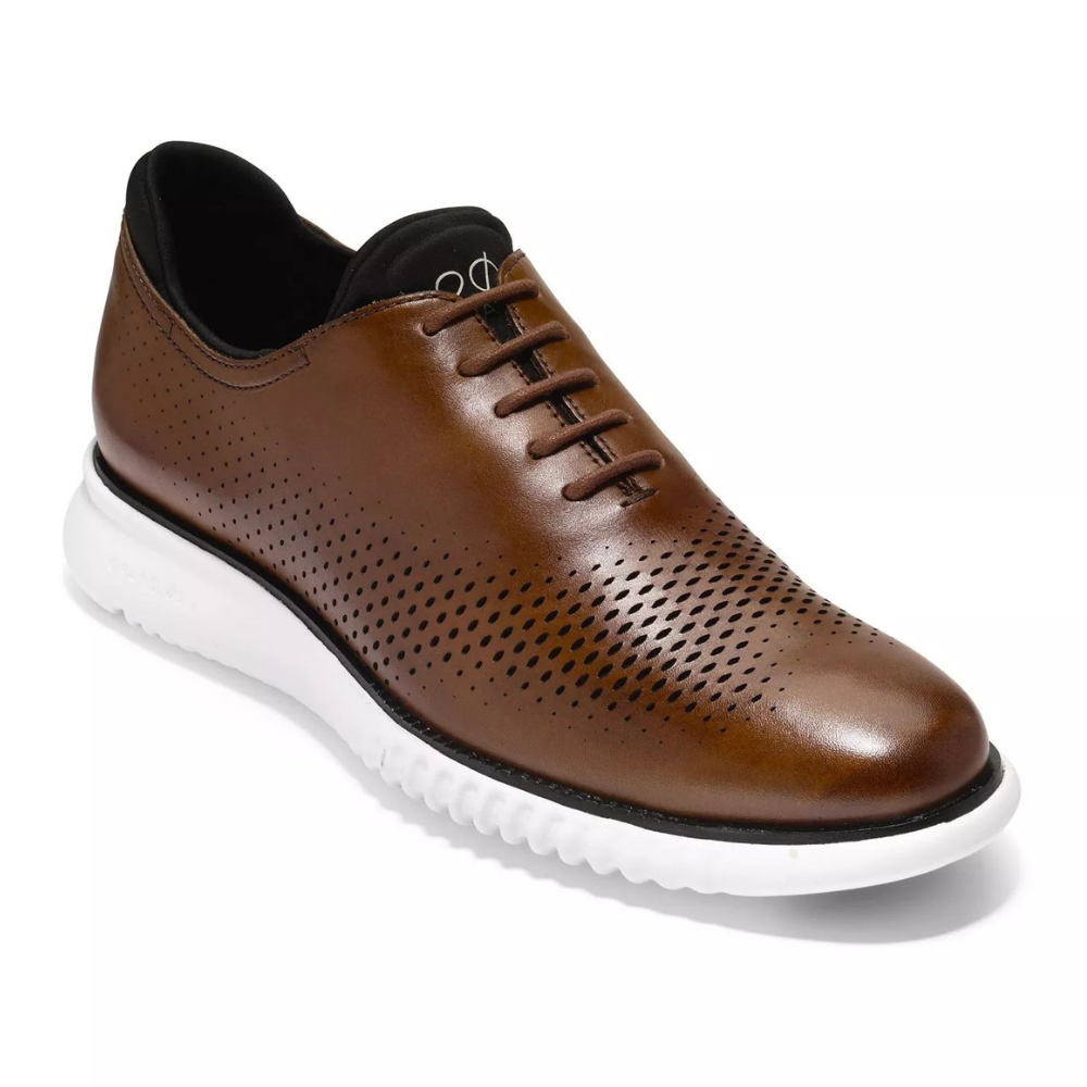 A brown leather shoe with perforated detailing and a white rubber sole, featuring a lace-up design for a casual yet stylish look.