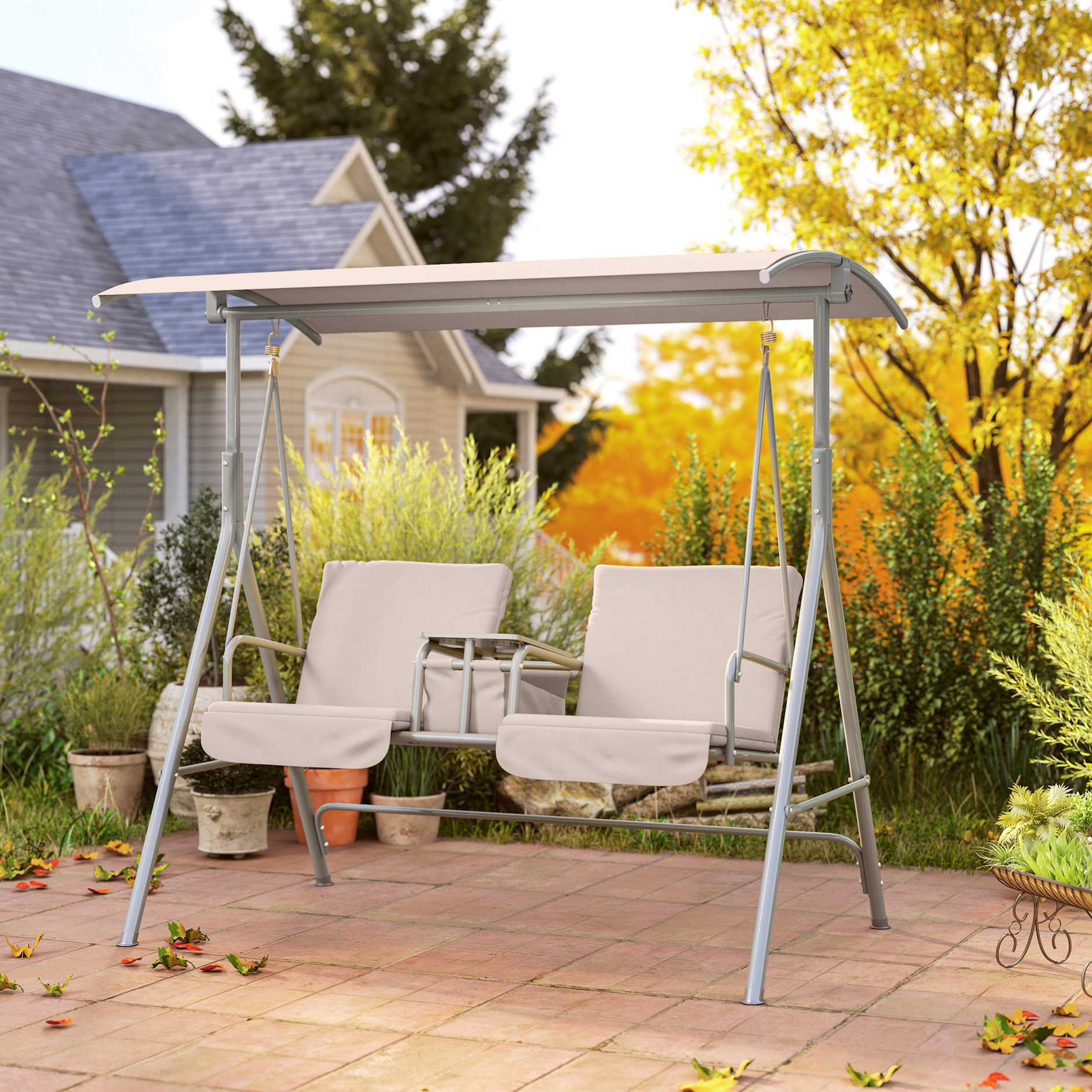 A beige two-seater garden swing with a canopy is set on a patio surrounded by greenery, offering a comfortable outdoor seating option.