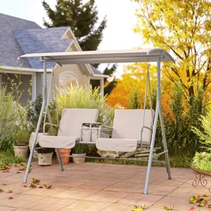 A beige two-seater garden swing with a canopy is set on a patio surrounded by greenery, offering a comfortable outdoor seating option.