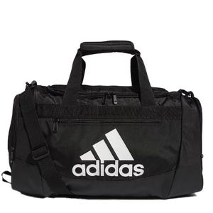Black Adidas Defender Duffel Bag featuring a prominent white Adidas logo, with dual handles and an adjustable shoulder strap, a front zippered pocket, and a durable base.
