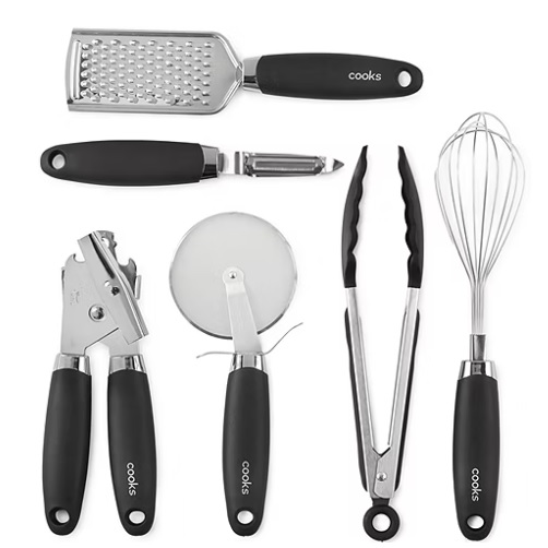 A set of kitchen utensils including a grater, peeler, pizza cutter, garlic press, tongs, and a whisk, all with black handles.