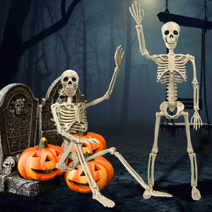 Two skeleton decorations are posed in a spooky graveyard setting with tombstones and three jack-o'-lanterns.